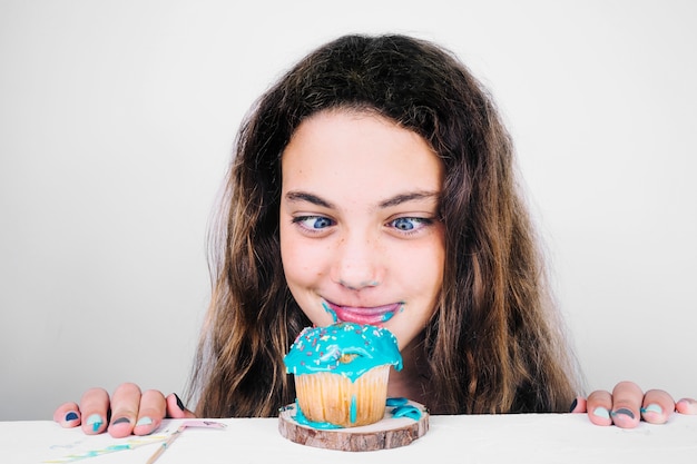 Teenager licking lips after eating muffin