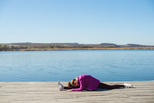 Free photo teenager performing split on pier