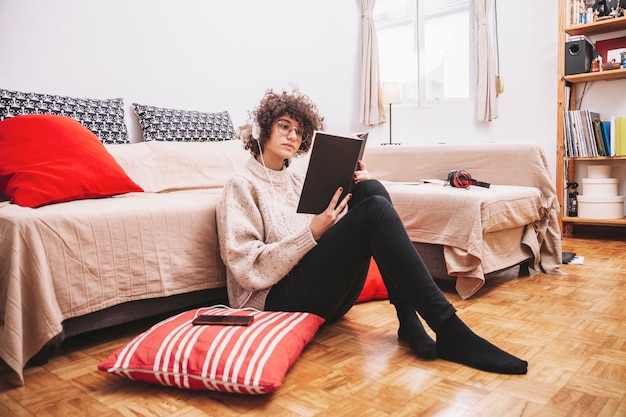 Teenager reading book on floor