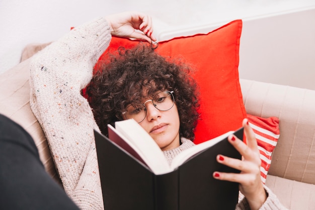 Teenager reading on sofa