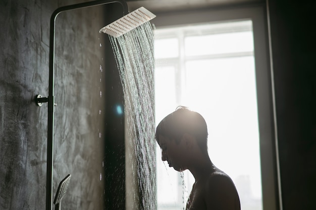 Free photo teenager taking a shower to reduce hangover effect