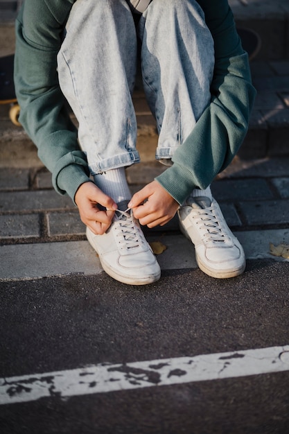 Teenager tying shoelaces outdoors