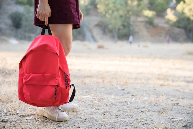 Free Photo teenager waiting with backpack in hand in park