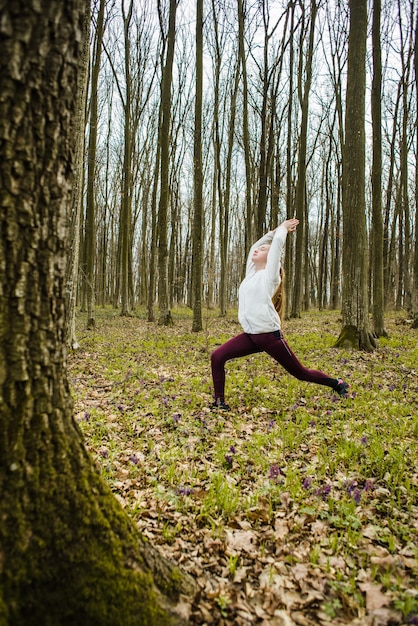 Teenager in warrior position in forest