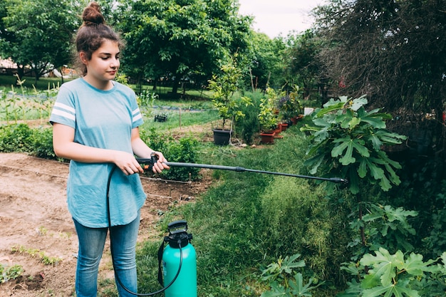 Teenager watering garden plants