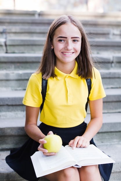 Free Photo teenager with book and apple