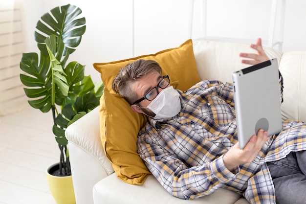 Free Photo teenager with face mask holding tablet