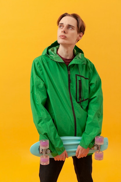 Free photo teenager with green jacket and skateboard