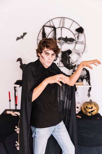 Teenager with Halloween grim making zombie gestures