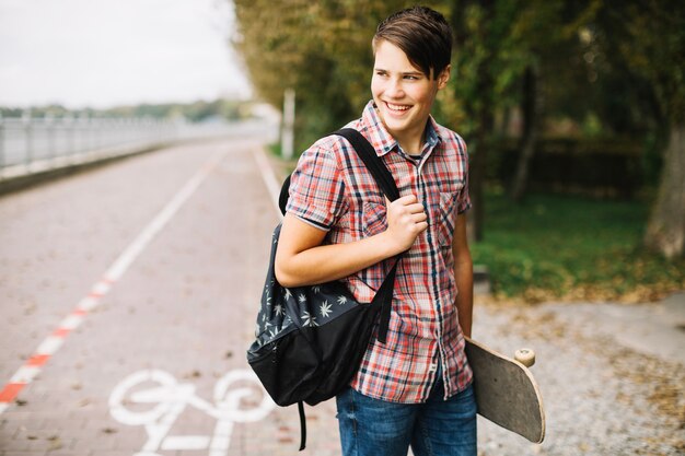 Teenager with skateboard and backpack