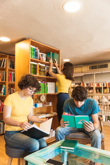 Teenagers reading near friend choosing book