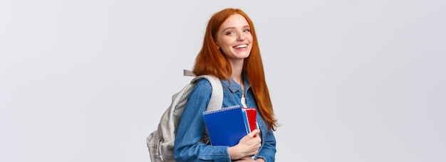 Free Photo teenagers students and education concept cheerful lovely redhead female studying going to univeristy