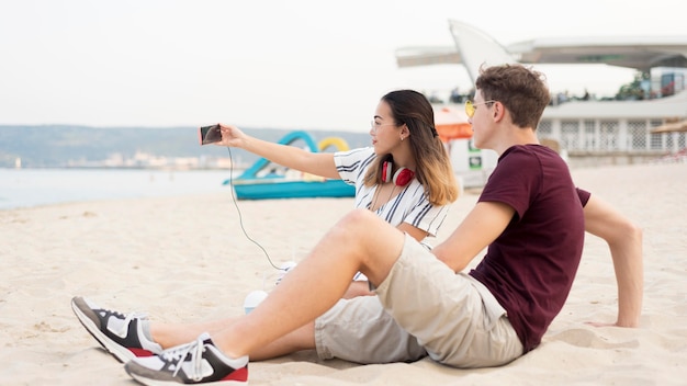 Teenagers taking a selfie together at the beach