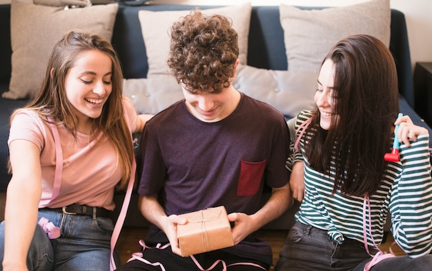 Teenagers unwrapping gift box