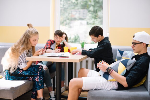 Teens spending time at table in class