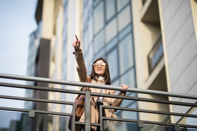 Tender brunette model walks on the modern bridge in the city center