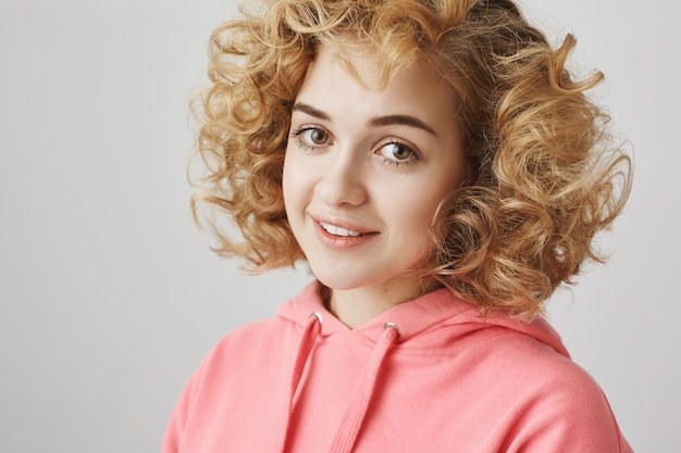 Free photo tender lovely curly-haired girl smiling at camera