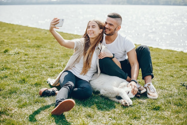 tender and merry lovers are having a good time at the lake with dog