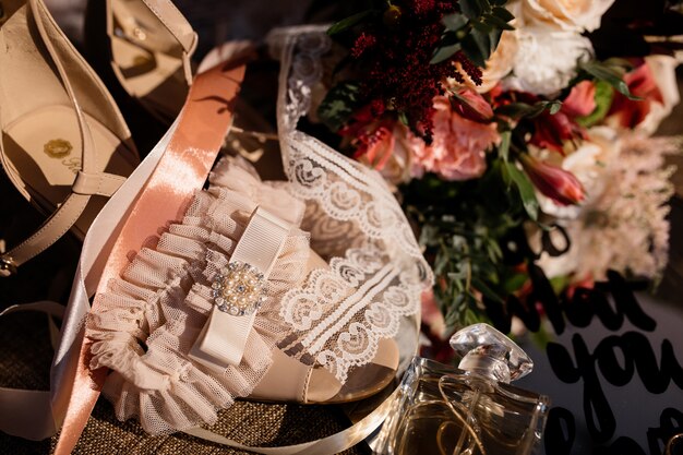 Tender wedding accessories for bride and wedding bouquet on the sunny day