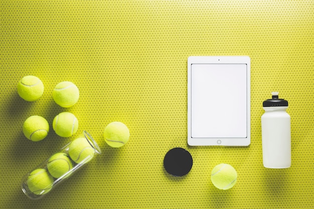 Tennis balls near tablet and bottle