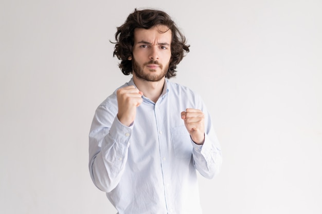 Tensed young man standing in boxing pose and looking at camera