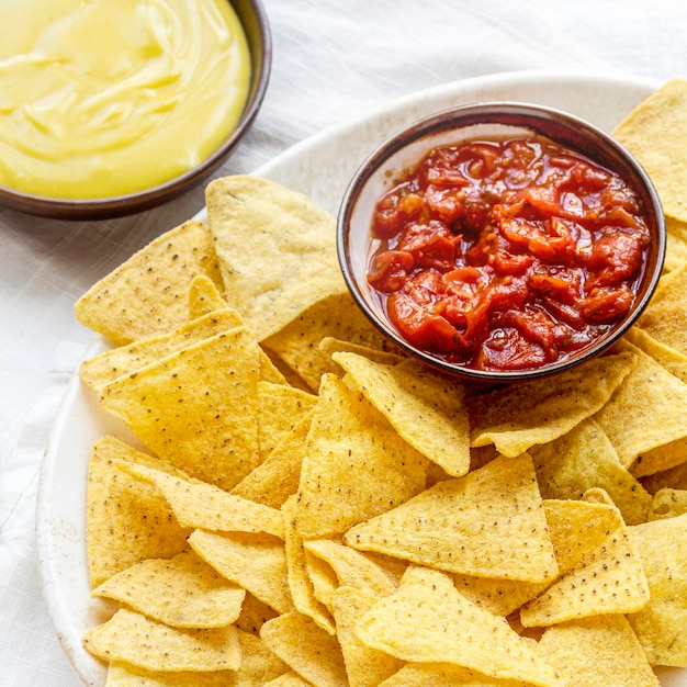 Free photo tex mex corn tortilla chips with cheddar cheese dip and salsa