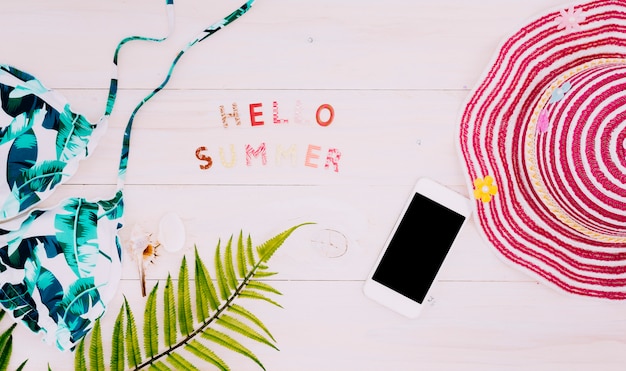 Free photo text hello summer with beach things on light surface