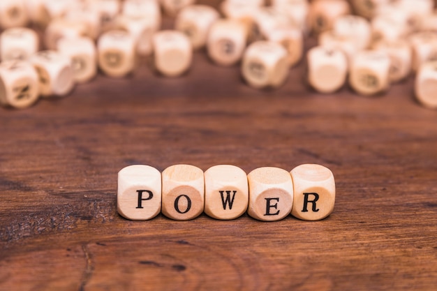 Free Photo text power written on wooden dices over brown desk