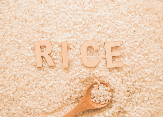 Free photo text on white rice grains with wooden spoon