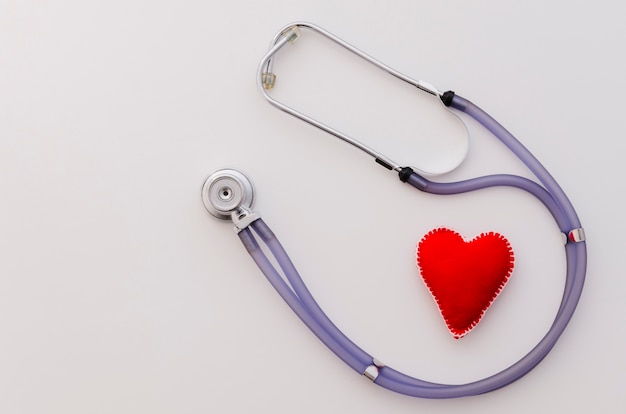 Textile red heart shape with stethoscope isolated on white backdrop