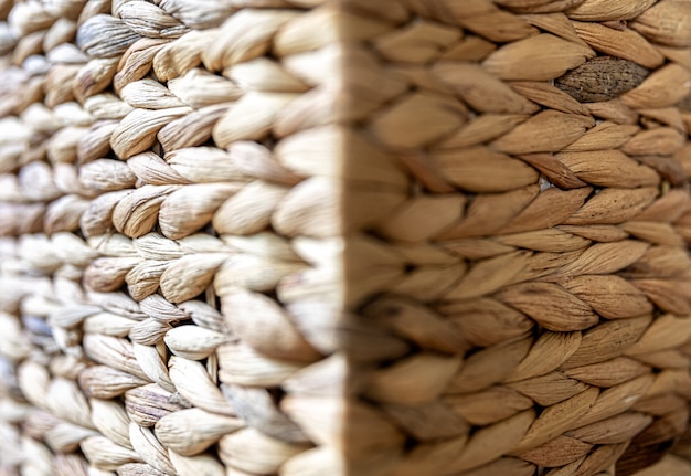 Texture of woven beige straw, background of braids from the plant stem close-up.