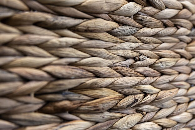 Texture of woven beige straw, background of braids from the plant stem close-up.