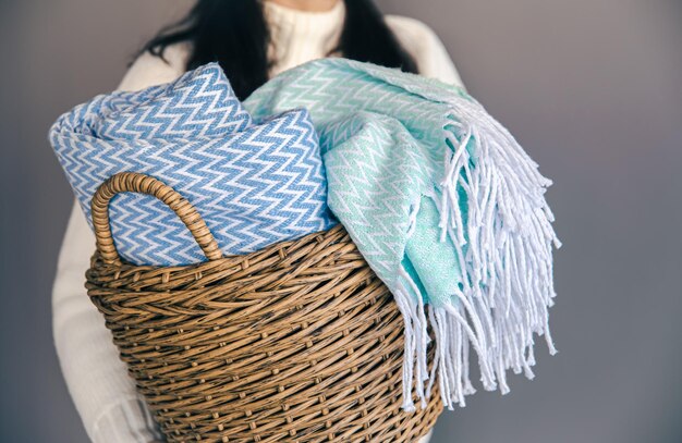 Textured plaids in a wicker basket on a gray background