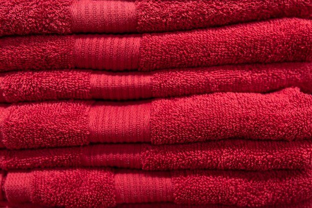 Textured red bath towels stacked close up