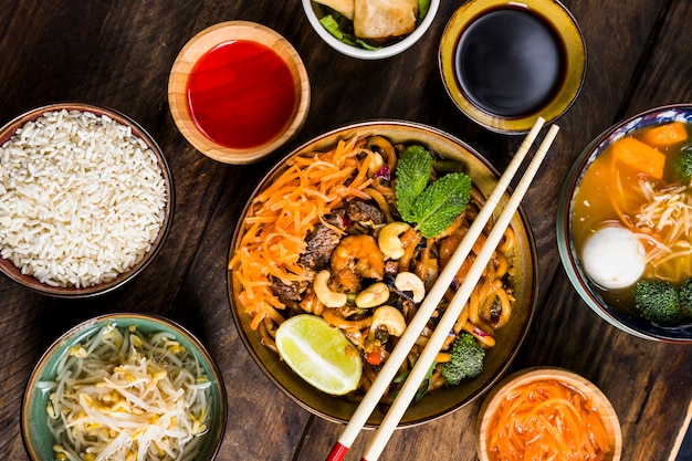 Free Photo thai cuisine udon noodles with soya sauce; rice; beans sprouts and soup on desk