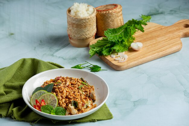 Thai food with spicy minced pork serve with side dishes and sticky rice