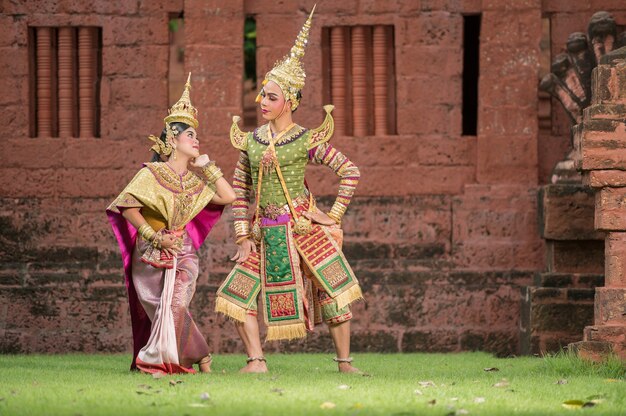 Thailand Dancing couple in masked Khon performances with ancient temple