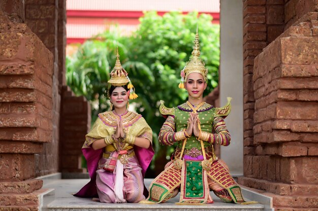 Thailand Dancing couple in masked Khon performances with ancient temple