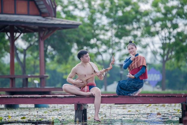 Thailand women and man in national costume with guitar pin ( Plucked Stringed Instrument)