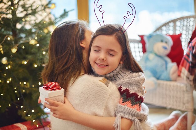 Thankful daughter with eyes closed hugging mother