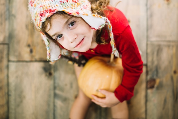 Free photo thanksgiving concept with girl holding pumpkin