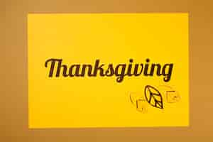 Free photo thanksgiving lettering with yellow leaflets on paper