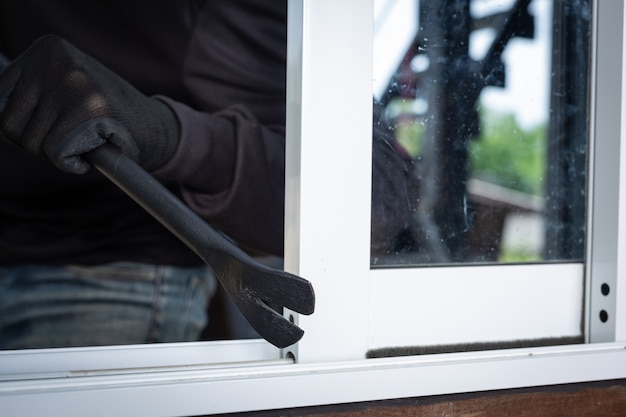 Free photo thieves wear black hats, pry windows, steal things.