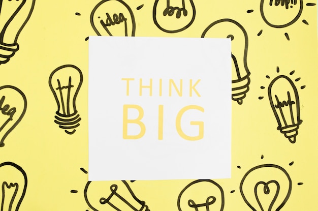 Think big text on hand drawn light bulb over the yellow background