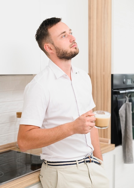 Thinker man in the kitchen with a cappuccino