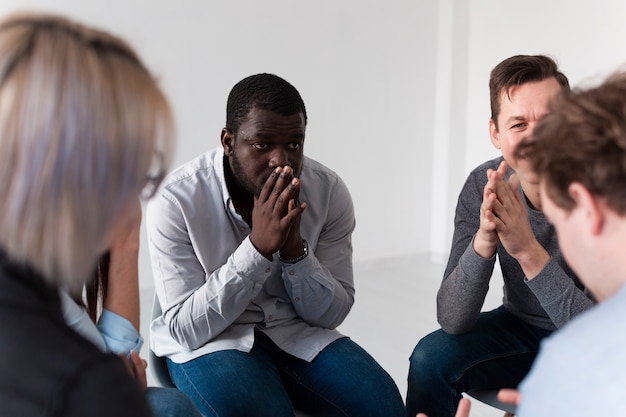 Thinking afro-american man looking at rehab patient