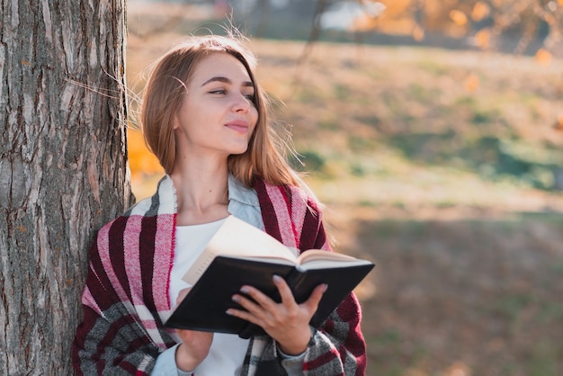 Thinking girl holding a notebook and looking away