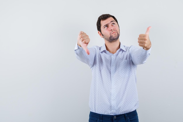 The thinking man is showing thumbs down and up on white background