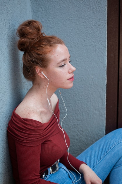 Free photo thinking young woman listening to music