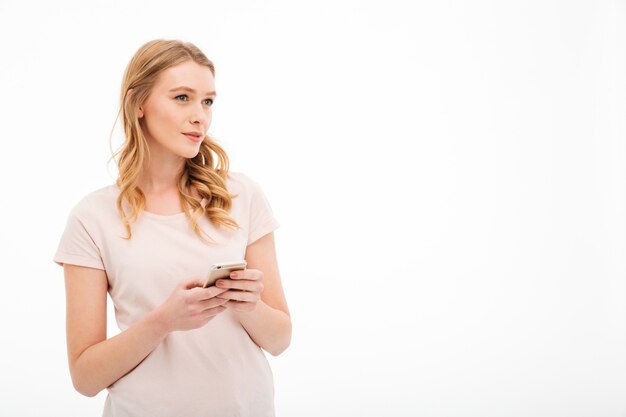 Thinking young woman using mobile phone.